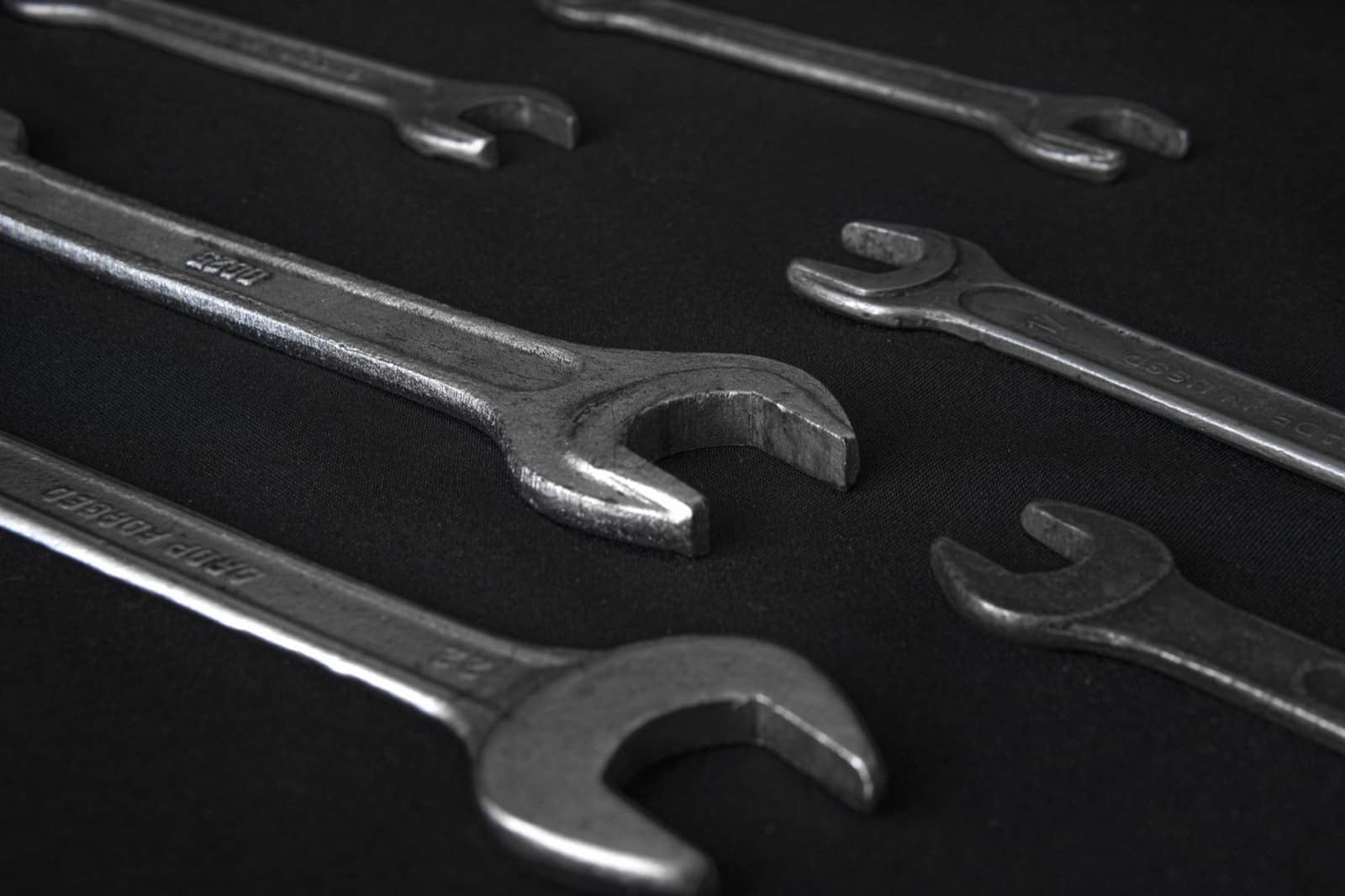 Open-end wrenches laid out on a black surface